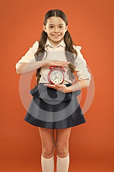 Elementary school day bell schedule. Schooltime concept. Schoolgirl child formal uniform hold alarm clock. Time to study