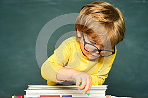 Elementary school and education. Schoolchild. Blackboard copy space. School kids. Funny little boy pointing up on