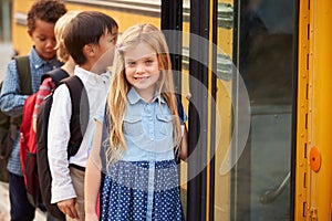 Elementary school girl at the front of the school bus queue