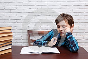 Elementary school kid biting a pen pondering over the task solut