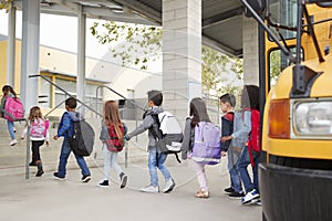 Elementary school kids arrive at school from the school bus