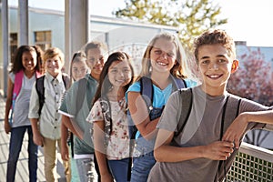 Elementary school kids with backpacks smiling to the camera