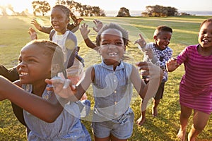 Elementary school kids running to camera outdoors, close up