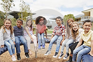 Elementary school kids sitting on carousel in the schoolyard photo