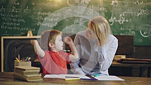 Elementary school. Preschool kid. Cute little boy studying at the class with a teacher.