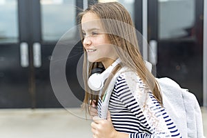 Elementary school pupil outside carrying rucksack