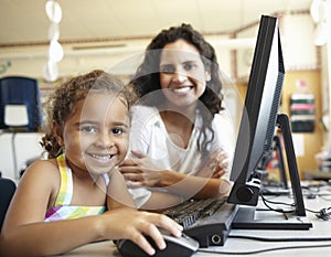 Elementary School Pupil With Teacher In Computer Class