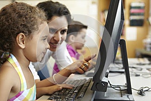 Elementary School Pupil With Teacher In Computer Class