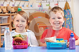 Elementary School Pupils With Healthy And Unhealthy Lunch Boxes