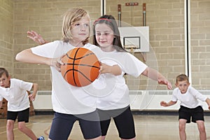 Elementary School Pupils Playing Basketball In Gym photo