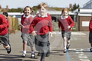 Elementary School Pupils Running In Playground