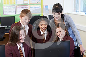 Elementary School Pupils With Teacher In Computer Class