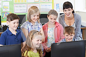 Elementary School Pupils With Teacher In Computer Class