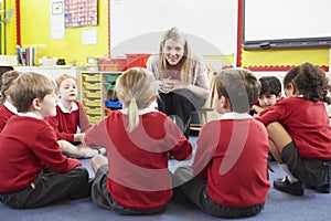 Elementary School Pupils Telling Story To Teacher