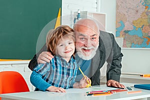 Elementary school. Smart pupil or schoolchild with senior teacher. Grandfather and son having fun together.