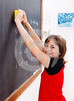 Elementary school student erasing chalkboard