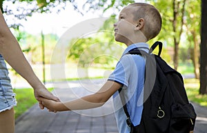 An elementary school student on his way to study. A first grader holds his mother& x27;s hand. The beginning of classes