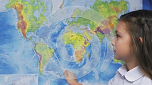 Elementary School Student Smiles by world map.