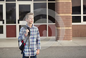 Elementary school student standing outside the school building