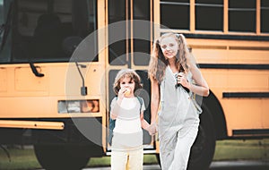 Elementary school students on school bus. Little ready to study. Happy little brother and sister standing together in