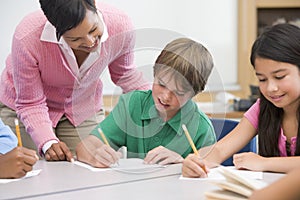 Elementary school teacher helping pupil photo