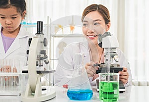 Elementary science class, Female teacher scientist with kid girl in school laboratory, Science laboratory