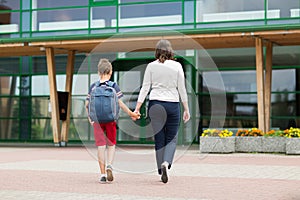 Elementary student boy with mother going to school