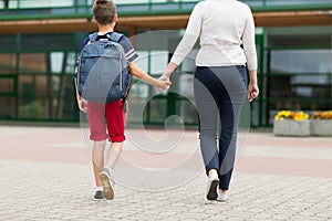 Elementary student boy with mother going to school