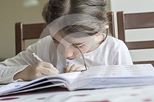 The elementry student is making her homework