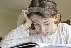 The elementry student is making her homework