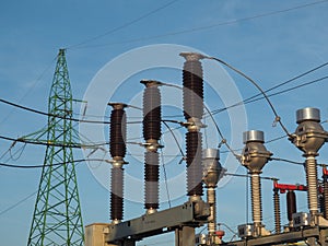 Green pylon, High Voltage circuit-breaker and current transformers at blue sky background photo