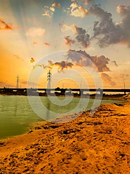 Elements of Serenity Clouds, Bridge, Lake, and Electric Tower Paint a Peaceful Landscape.