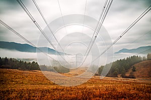 Eletric wires over foggy misty country