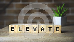 Elevate word written on wood block, business concept. photo