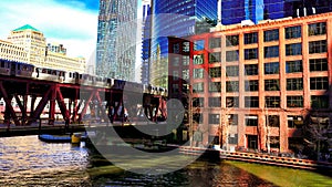 Elevated `el` train passes over the Lake Street bridge, crossing the Chicago River in the Loop.