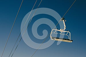Elevated passenger ropeway on a sunny day with a blue sky in the background