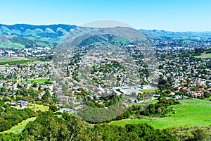 Elevated scenic view of San Luis Obispo urban area sprawl and green mountains of Santa Lucia Range from Bishop Peak Trail on sunny