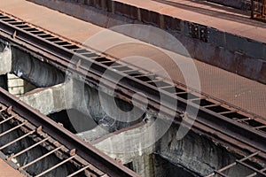 Elevated train tracks with rusted metal walkways alongside