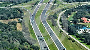 Elevated view of freeway exit junction over road lanes with fast moving traffic cars and trucks. Interstate