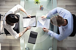 Elevated View Of Two Businesspeople Holding Resume