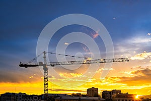 Elevating construction crane against the background of the sunset sky.