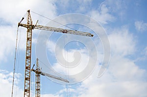 Elevating crane against the cloudy sky