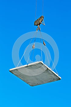 Elevating crane lifting a concrete plate