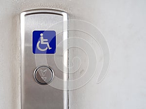 Elevator button with blue disabled people sign on elevator panel