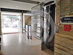 Elevator doors, close lift cabin entrance with chrome metal buttons panel, empty building interior, hotel or dwelling lobby