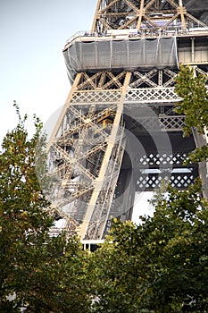 An elevator in the Eiffel tower seen through the trees