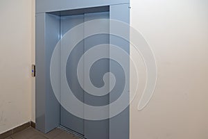 The elevator entrance is in modern office with marble wall. Lift transportation floor to floors with push switch for up and down