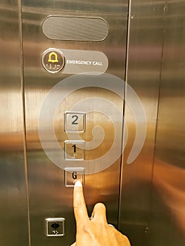 Elevator service concept. Finger pressing button in elevator.