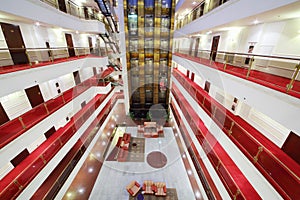 Elevators, lobby with armchairs and floors with many doors