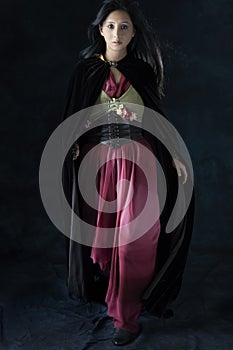 An elf warrior queen wearing a laced bodice and draped skirt against a studio backdrop photo